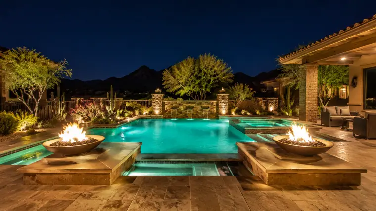 Piscina de noche con cuencos de fuego